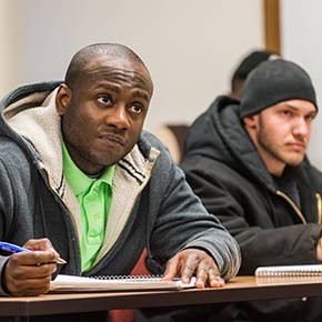 A student smiling with colleagues