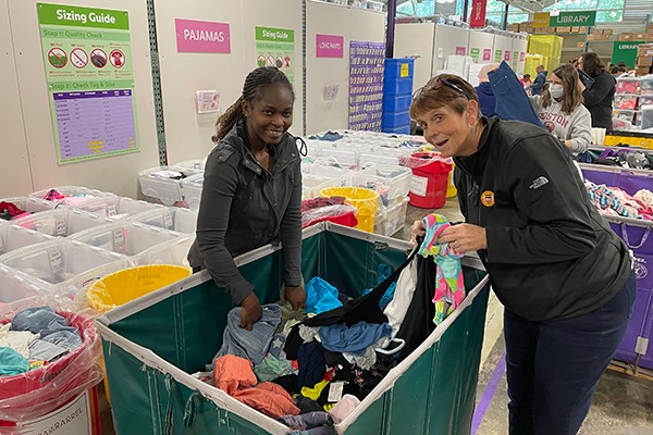 Sister Jeanne and student sorting clothes at Cradles to Crayons