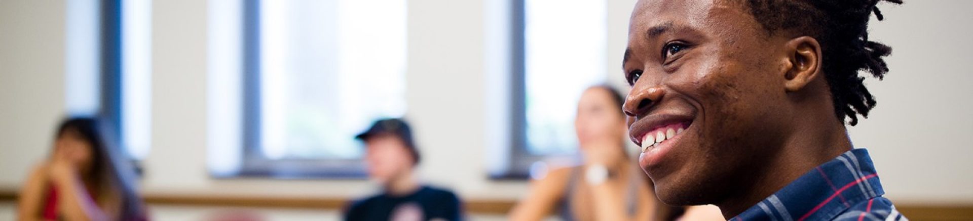 student sitting in a classroom and smiling