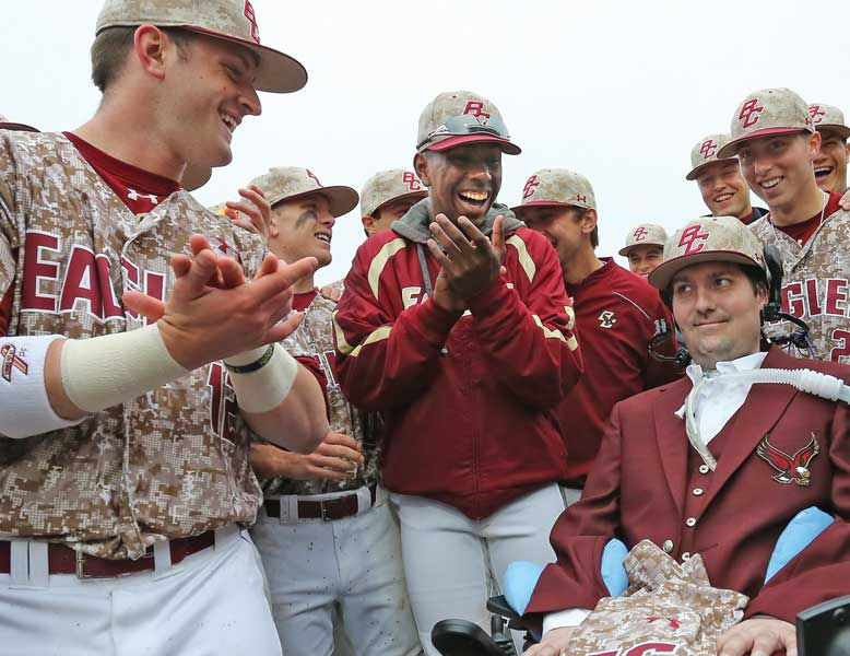 Frates seated with baseball team applauding him