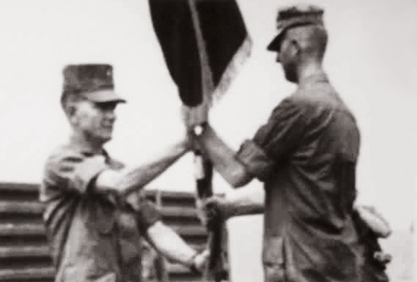 Photograph of Lt. Colonel Joseph R. Dobbratz passing a flag to Lt. Colonel Merlin V. Statzer