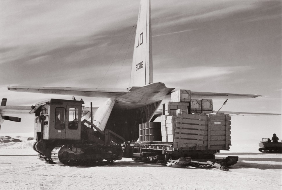 Forklift loading a plance in a snowfield