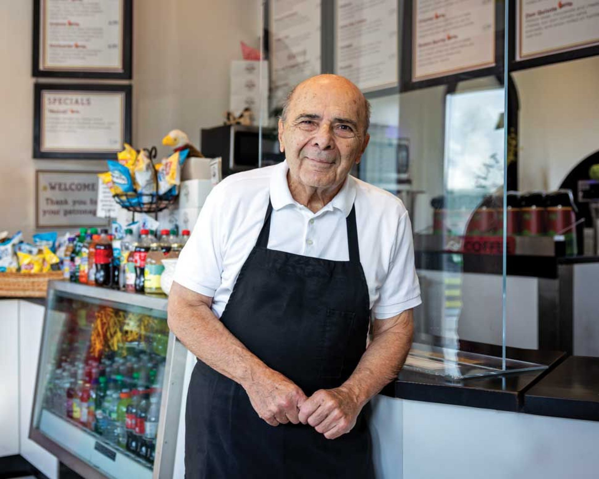 Photo of John Acampora at the counter of his Flat Breads shop