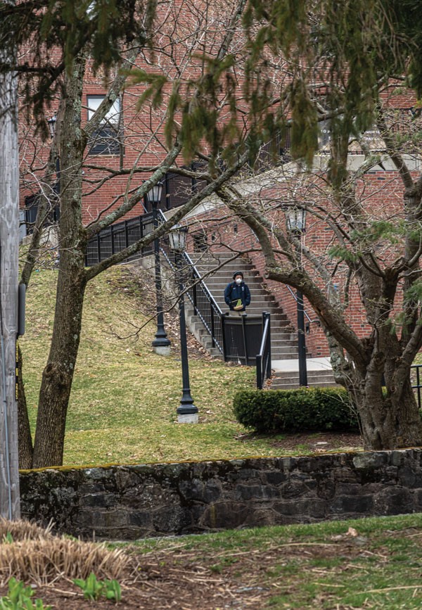A lone person walking down stairs on upper campus.