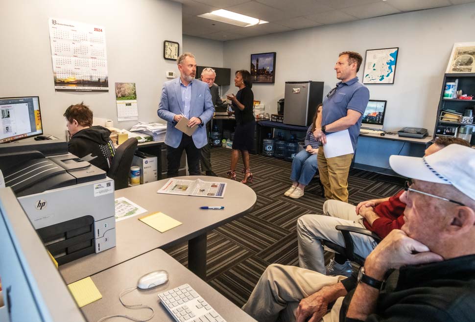 Photo of the staff dicussing content around a computer monitor.