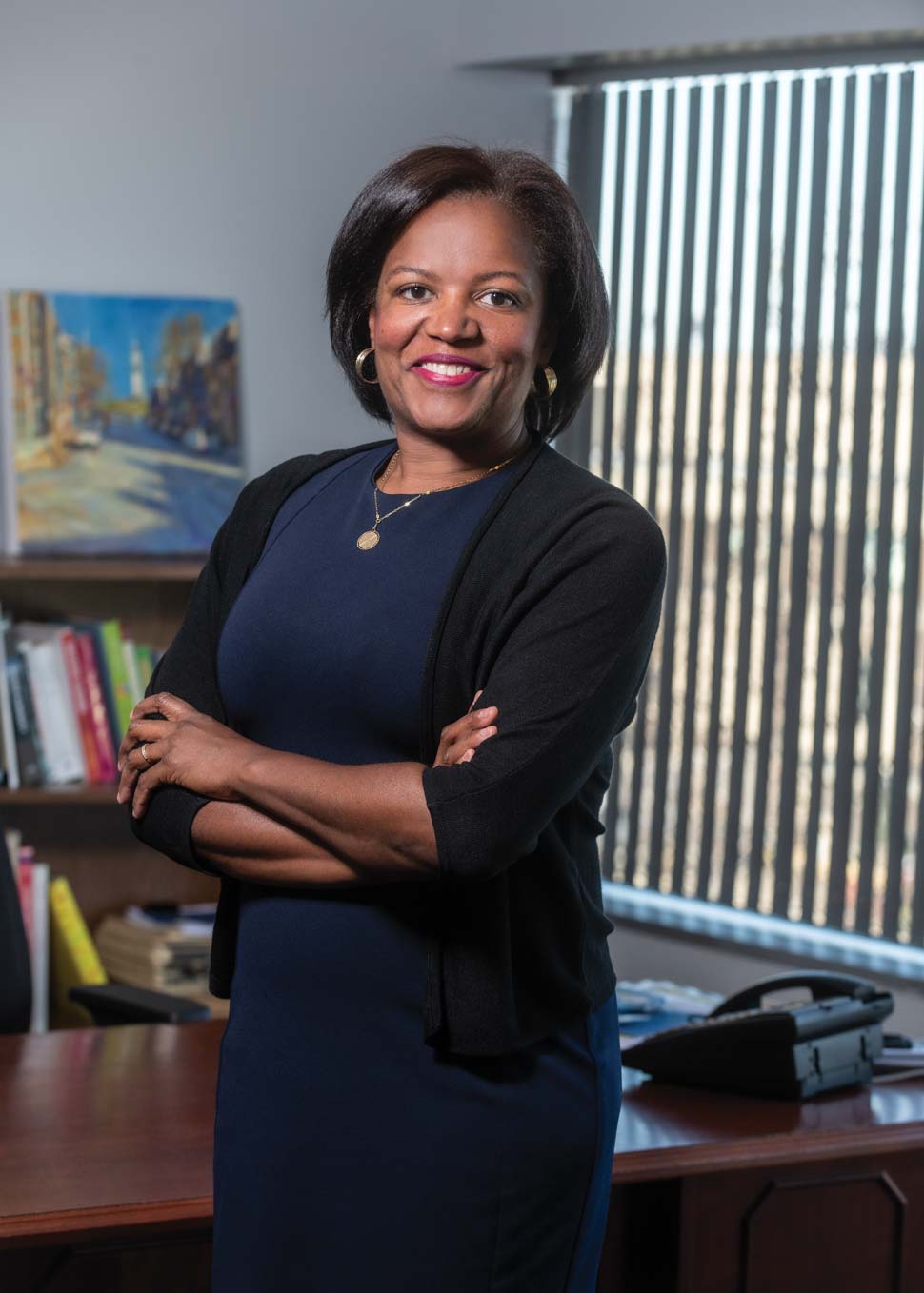 Photo of Linda Dorcena Forry standing in front of her desk and window.