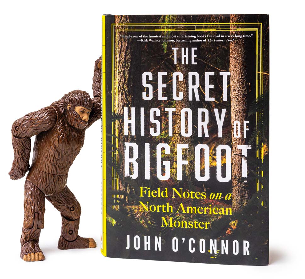 A toy Bigfoot figurine standing next to the excerpted book.