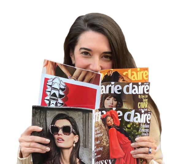 Sally Holmes holding three Marie Claire magazines.