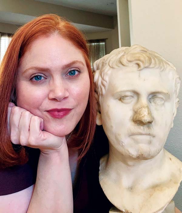Photo of Laura Young next to the ancient bust