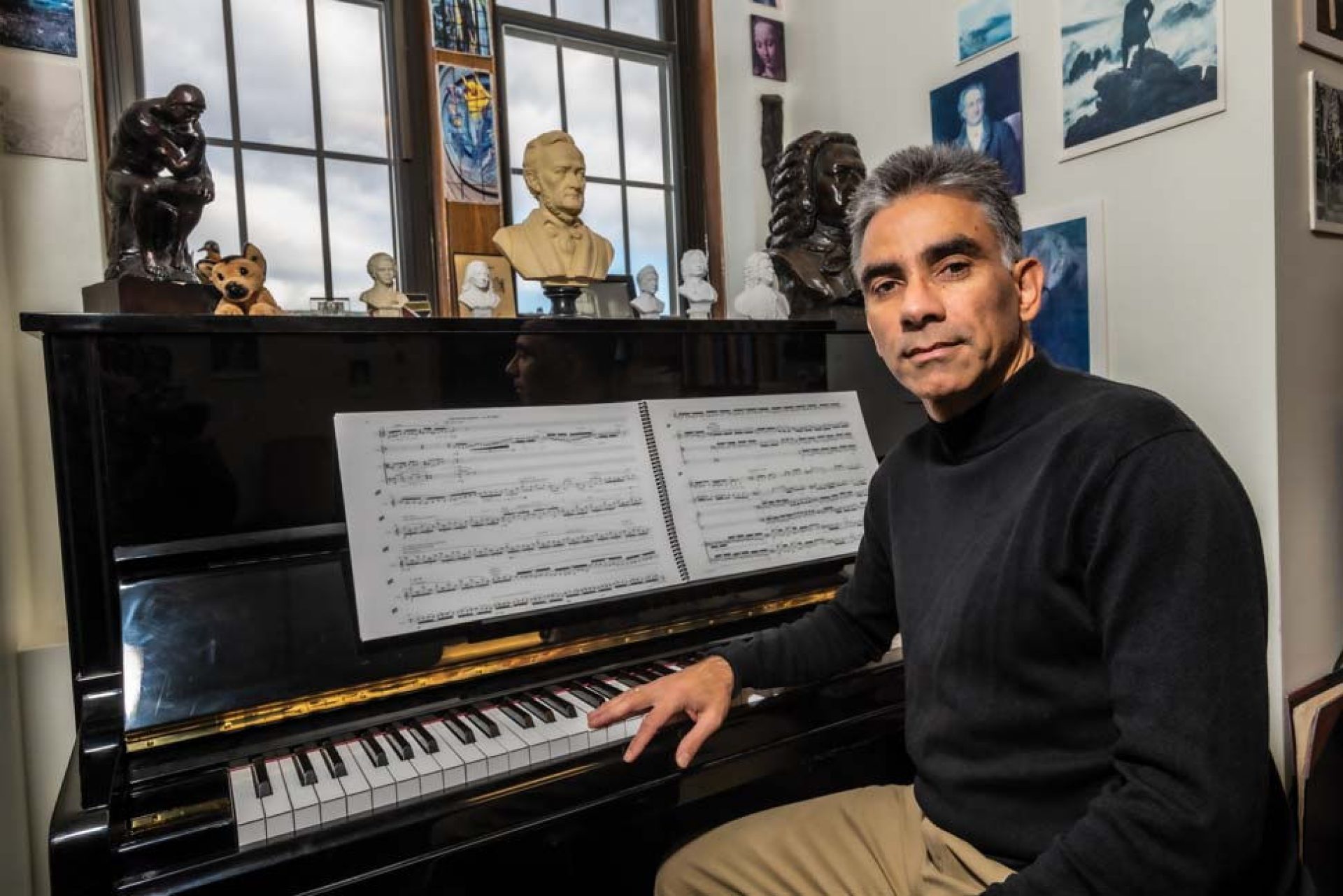 Ralf Gawlick seated at the piano in his office