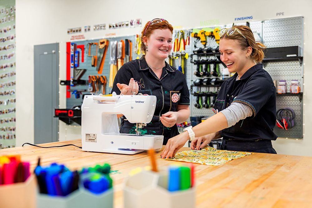 Two students using a sewing machine