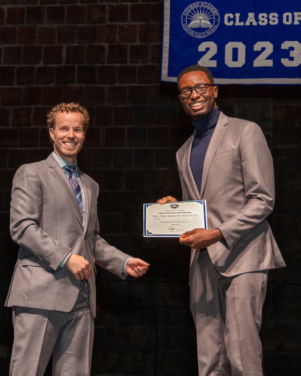 Brian U. Nwafor (at right), assistant director of The Academy at BC's Pine Manor Institute for Student Success, accepts the award from Daniel Hoffman, dean of college and career advising at Codman Academy.