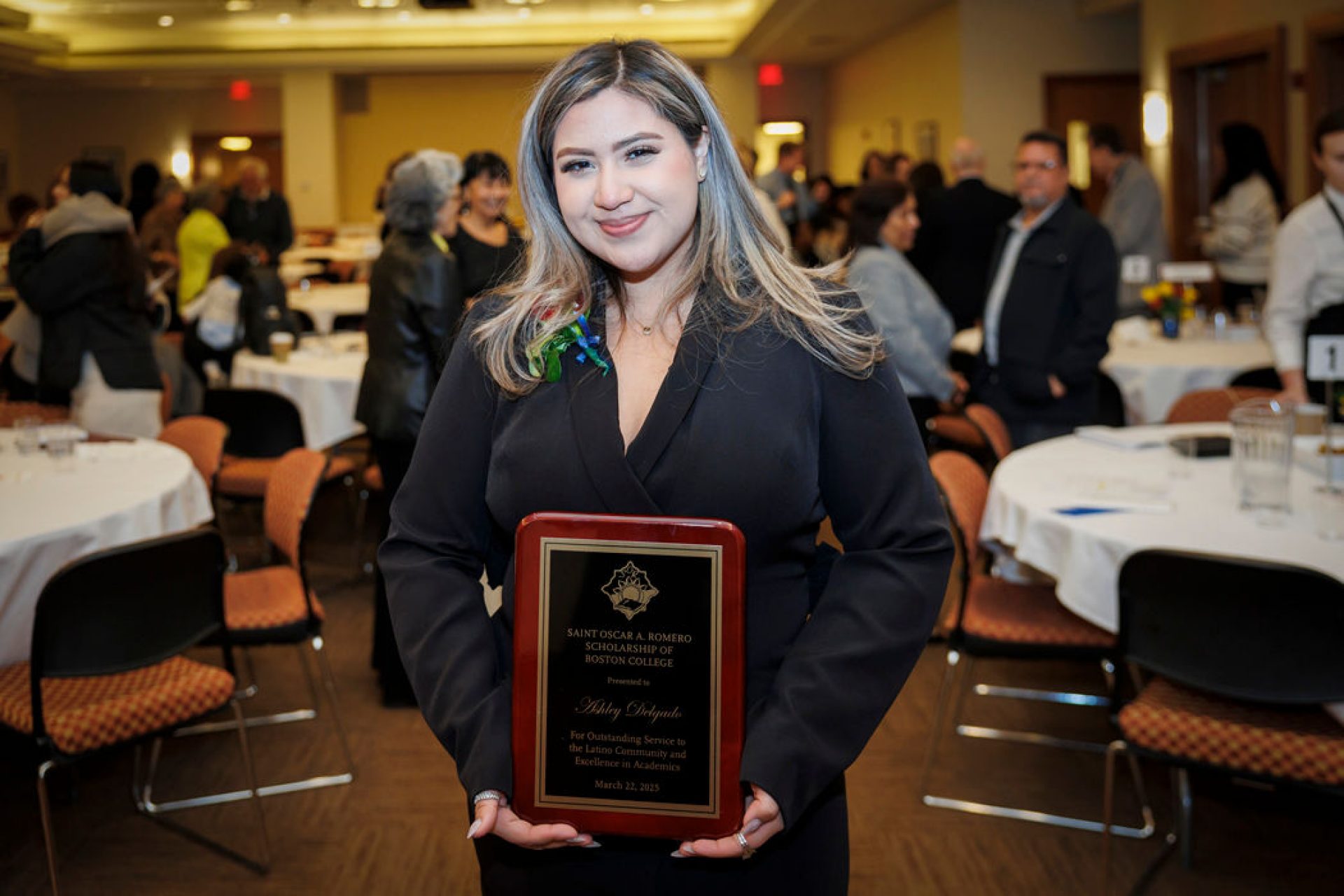 A student holding an award plaque