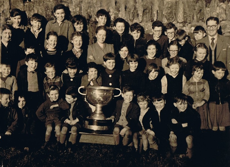 A group of children posing with a cup