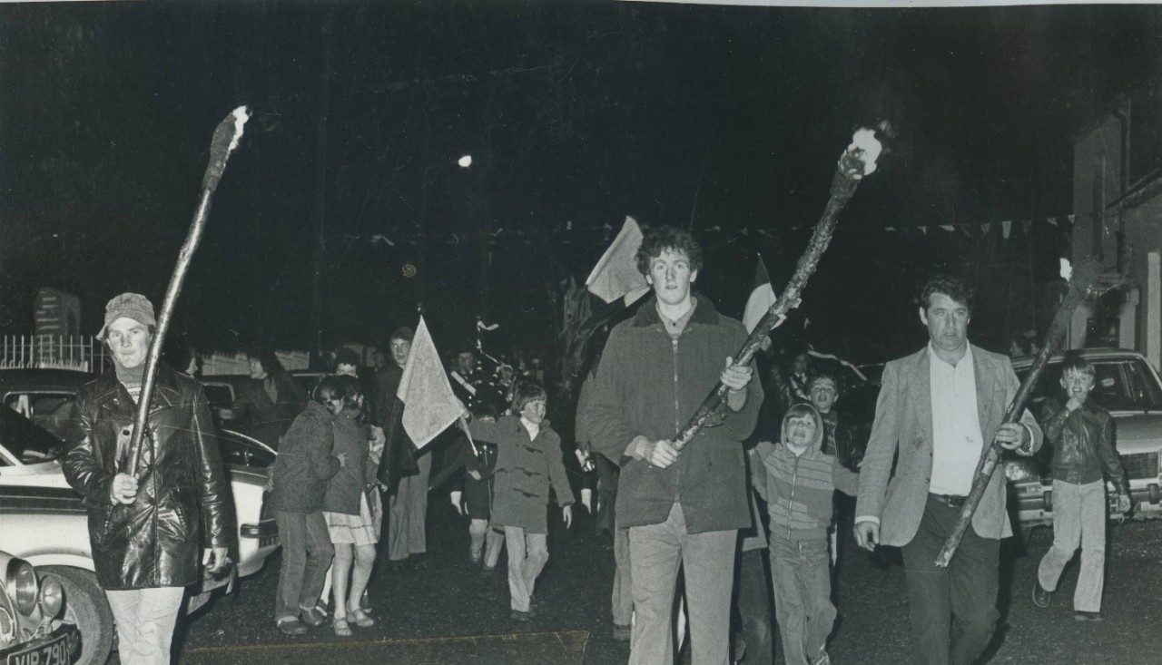 People walking in the street with torches