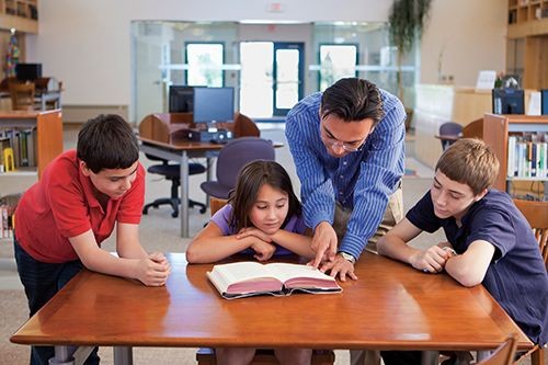 Teacher working with young students