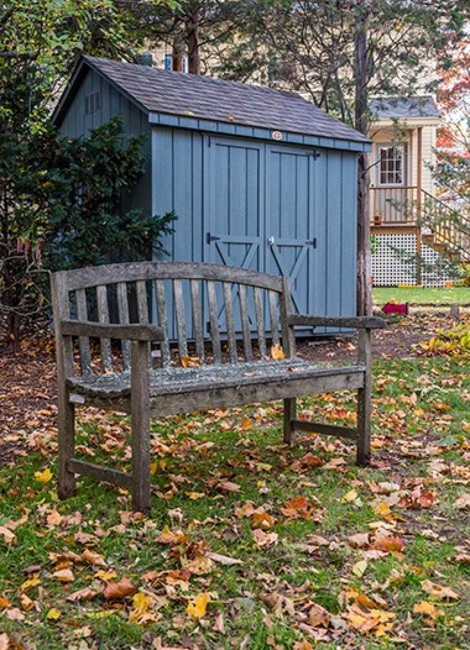A bench in front of a blue shed