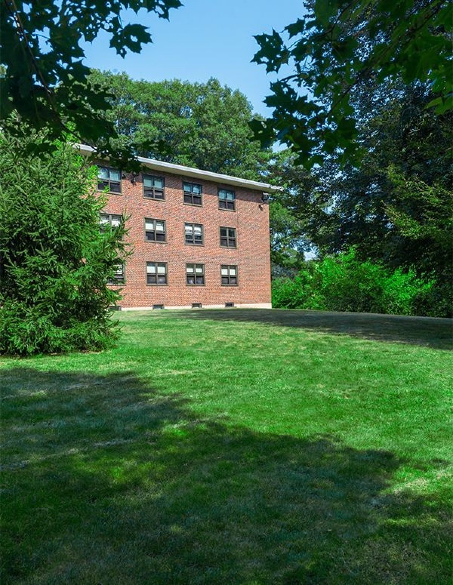 A lawn in front of a brick building