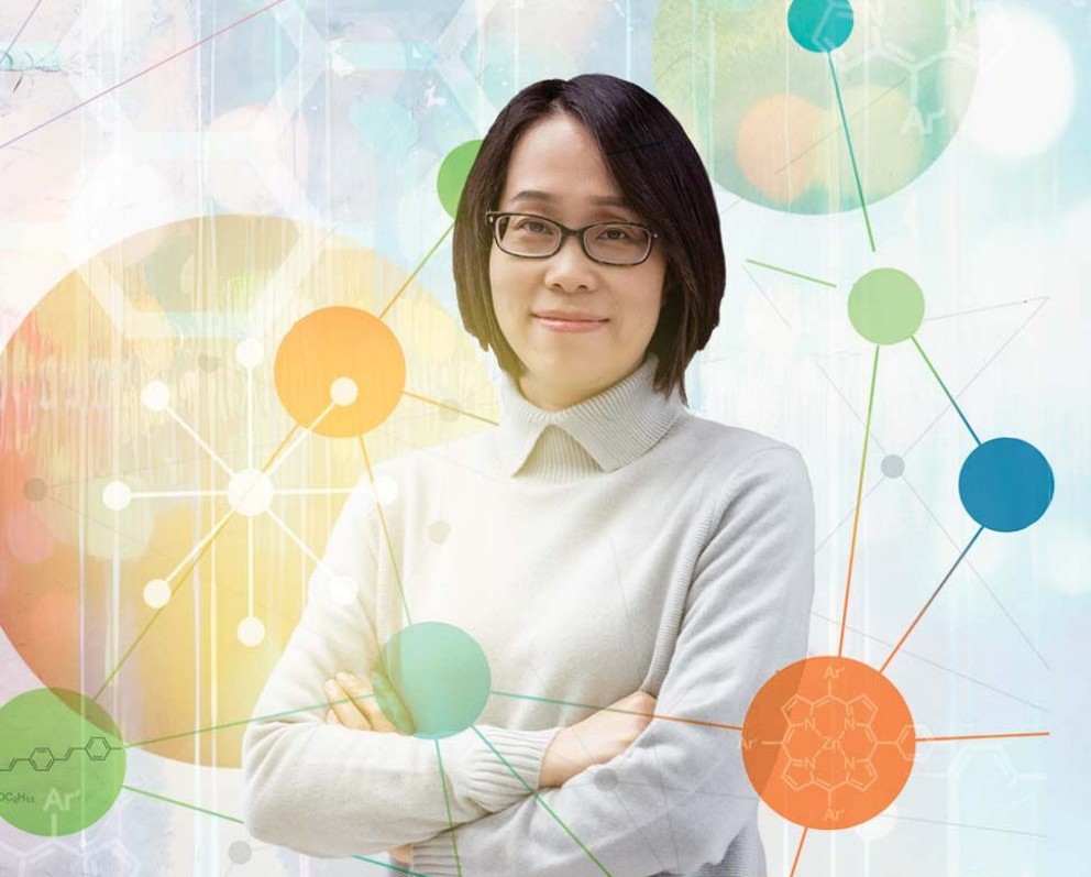 Jier Huang in front of abstract background with chemistry symbols