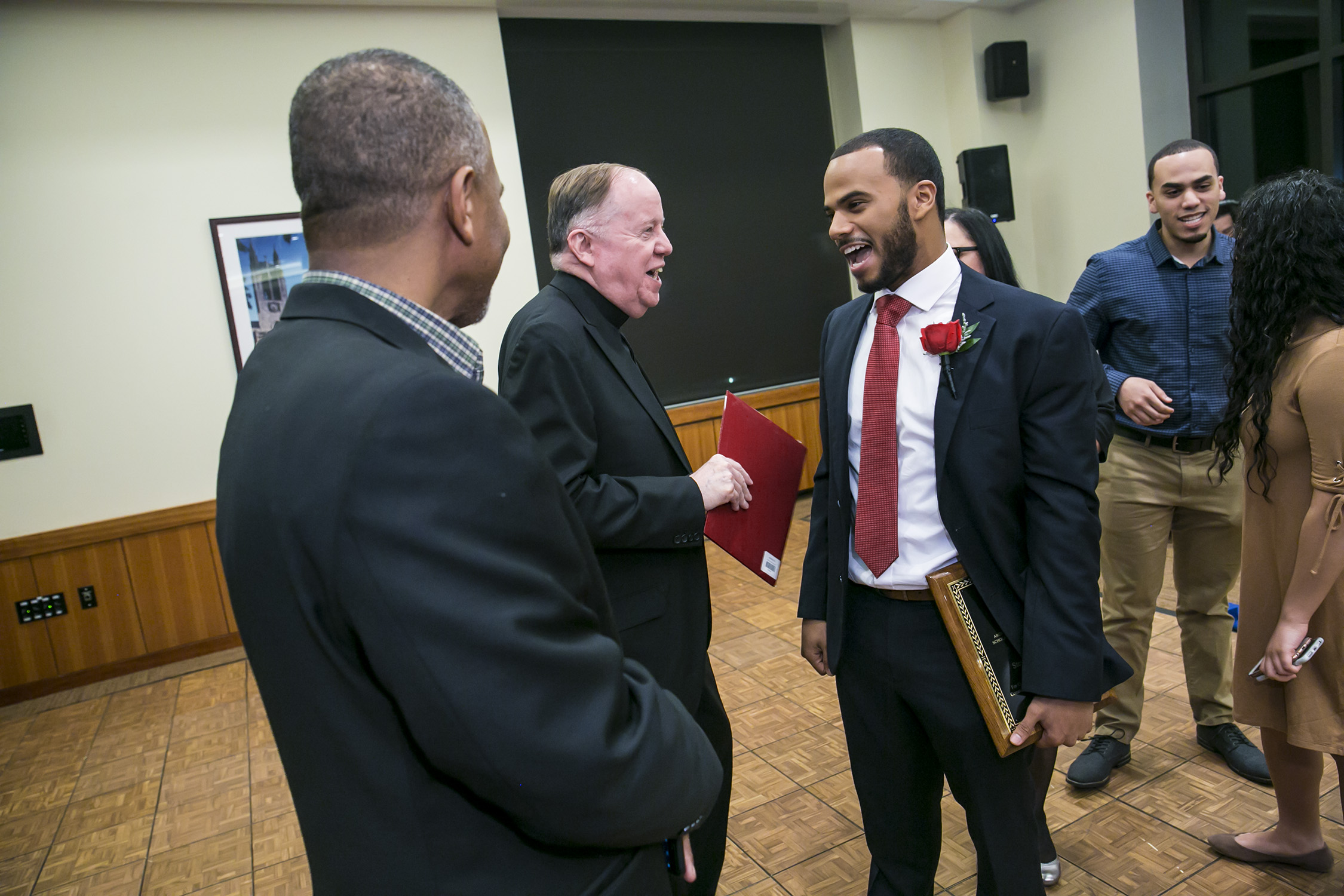 Archbishop Oscar Romero Scholarship winner Steven Guerrero '18 shares a laugh with Boston College President William P. Leahy, S.J., and Guerrero's father, Pablo.