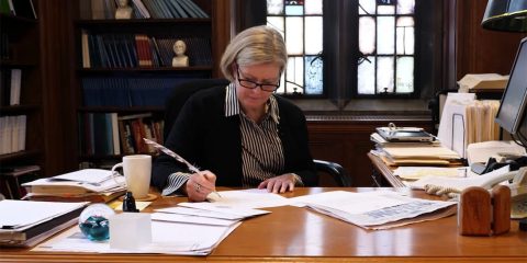 Screenshot from 'Special Delivery' video showing a professor writing at a desk