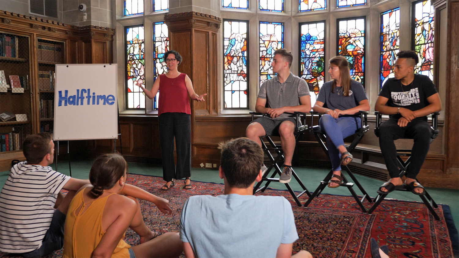 A group presenting in front of stained glass windows