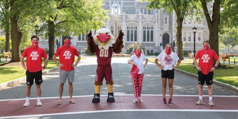 Students and the BC mascot wearing red bandanna masks