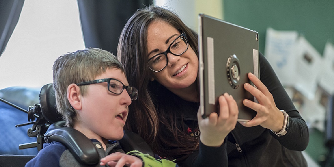 A student working with a teacher on an iPad