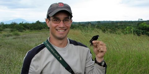 A man with a bird perched in his finger