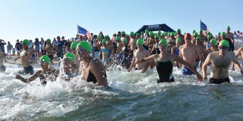 Swimmers in bathing caps standing in the water
