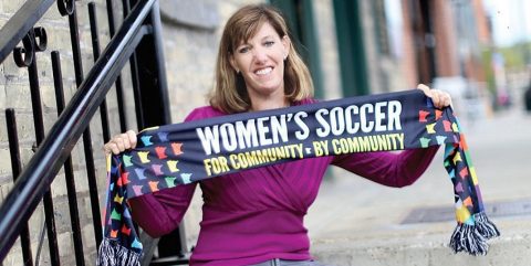 Andrea Yoch holding a women's soccer banner