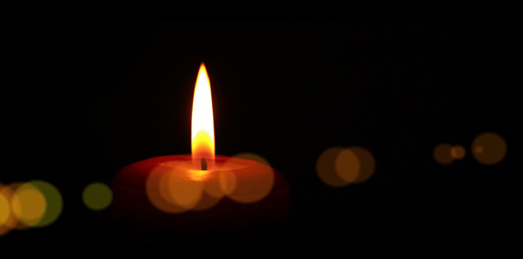 lit candle on dark background