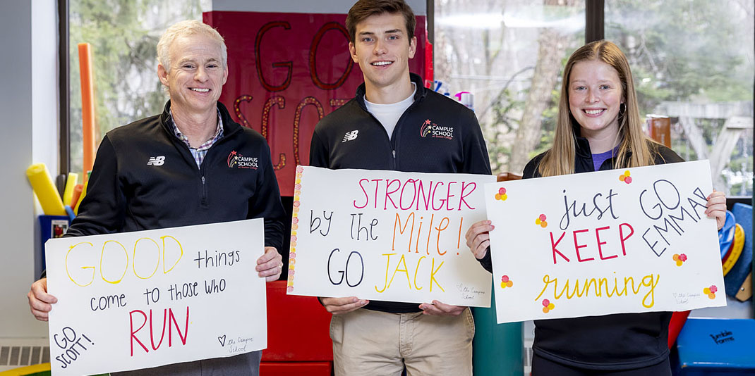 Three runners holding signs