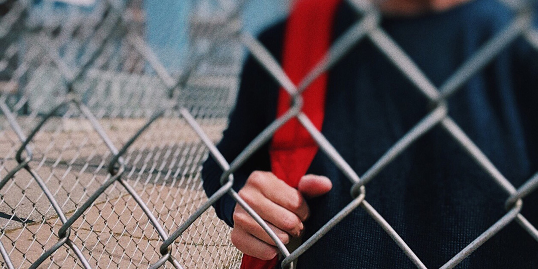 teen behind fence