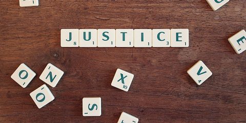 scrabble tiles spelling 'justice'