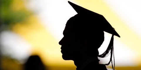 Graduate in cap and gown; silhouette