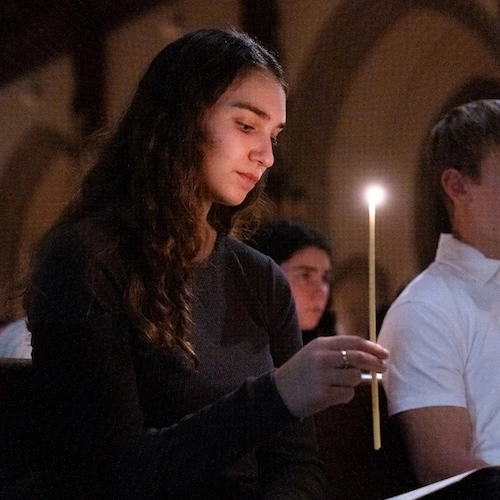A BC student holding a candle during the Advent Mass.
