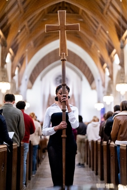 Boston College student holding a cross at Mass.