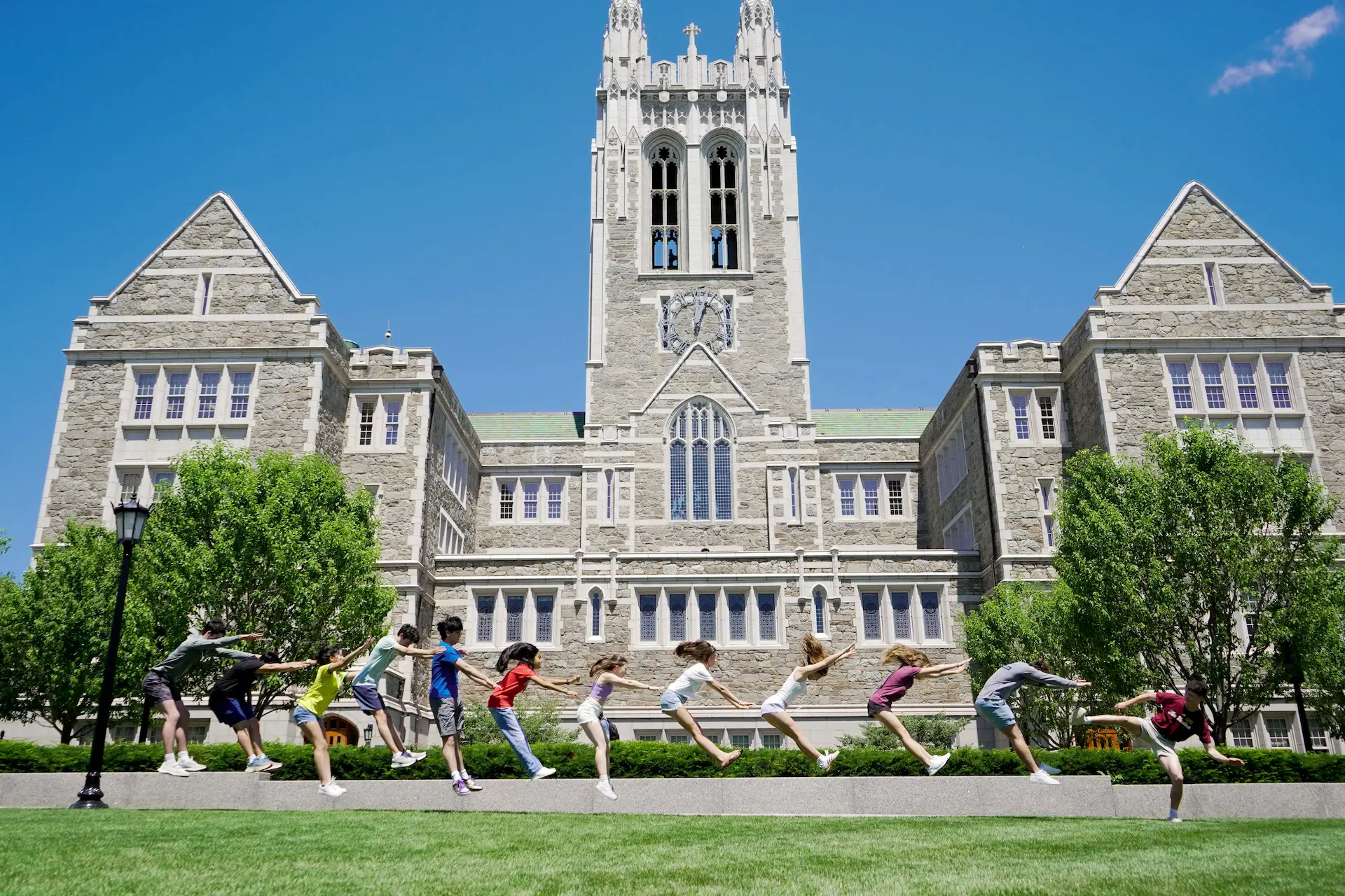 group of boston college students sitting and talking on the grass