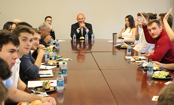 students at a conference table with Ferit Şahenk ’89