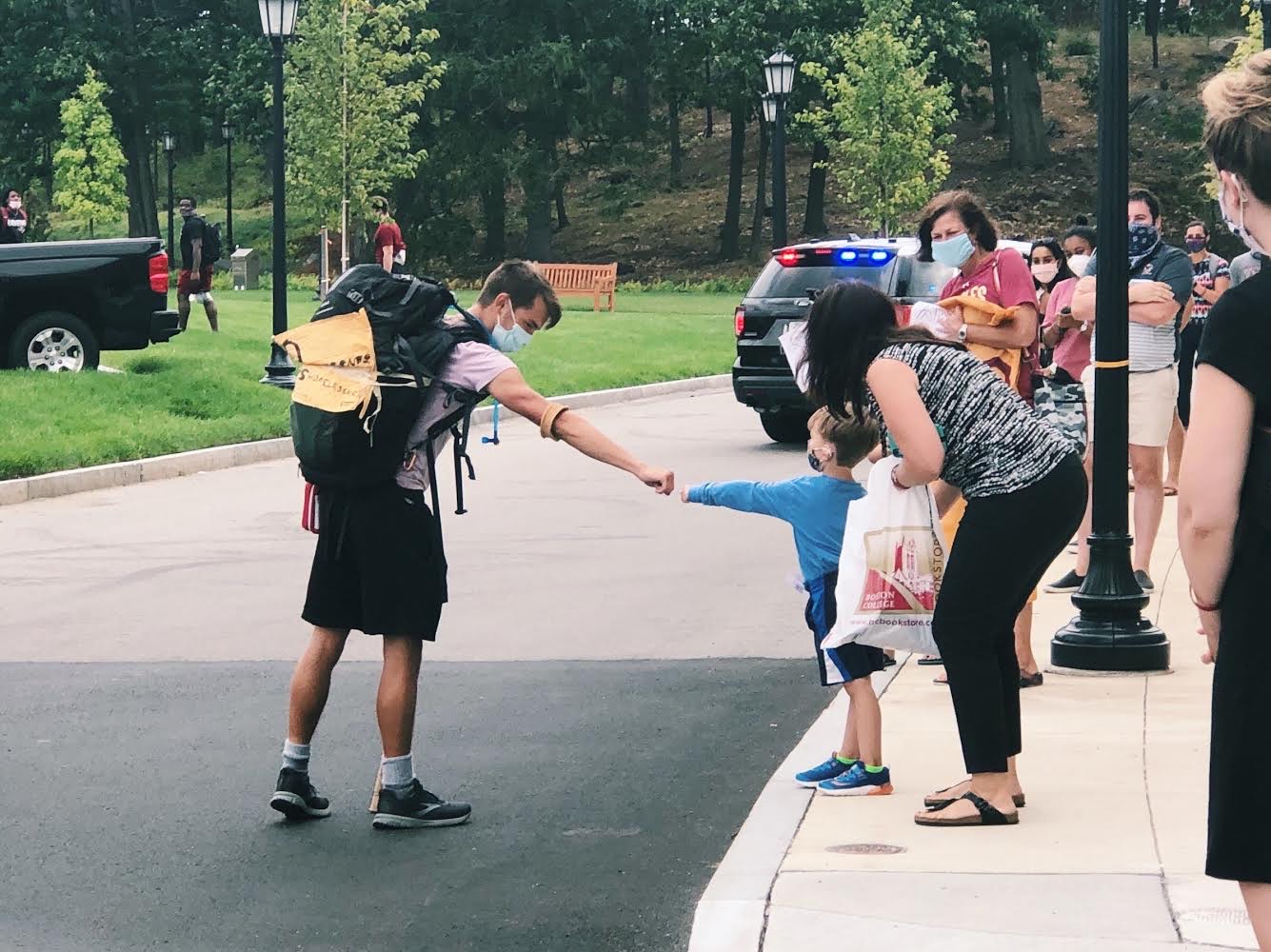 Gordon Wayne fist bumps a child after arriving on BC's campus