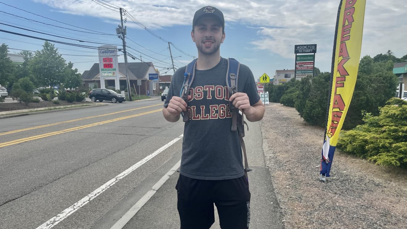 Charlie Martin with his backpack on the side of the road