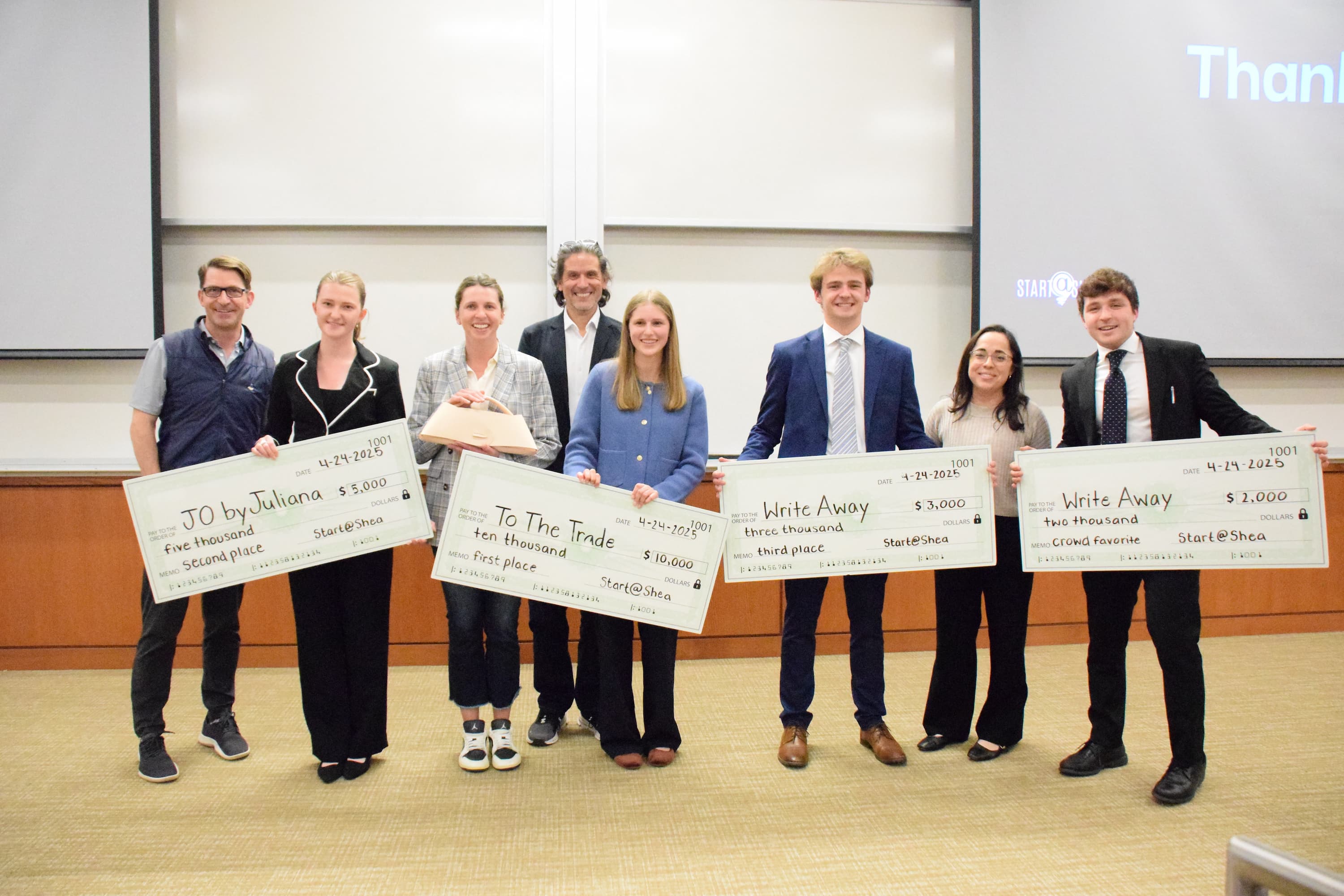 The winners of the Strakosch Venture Competiton pose with their prize money checks and the judges of the competiton.