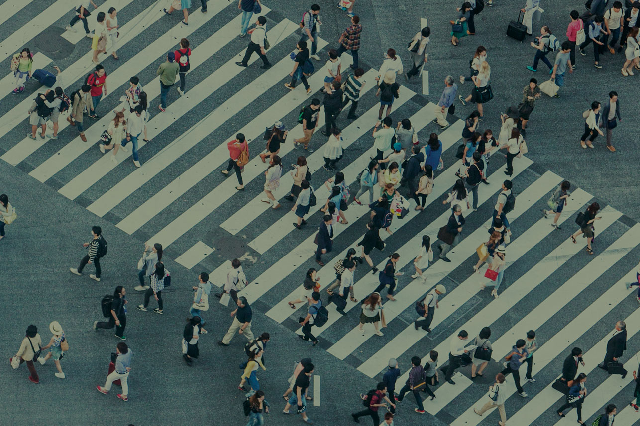 Crowd of people walking busy New York City street backlit