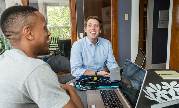 Smarter in the City team members Team members of the first cohort of Smarter in the City photographed at Smarter headquarters in Dudley Sq., Boston, MA. Ross Pini (LAW '15), blue shirt and Joel Edwards, principal of Fittus in grey t-shirt have a working meeting. Photographed for Summer '15 issue of BCM.