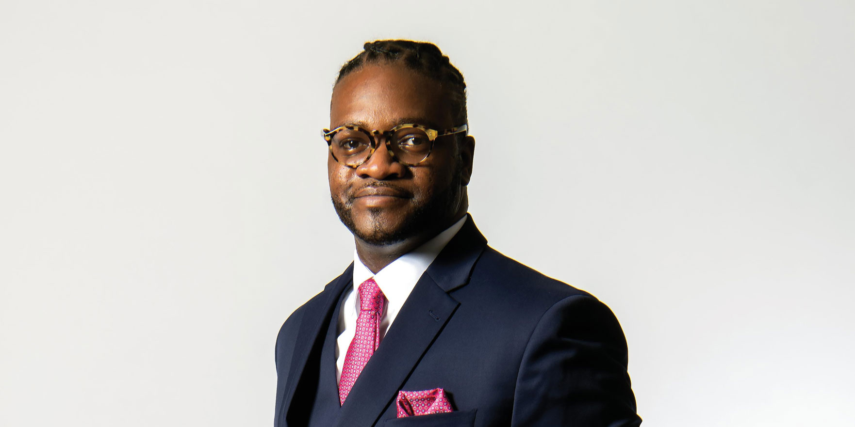 Charles Grandson in dark suit and pink tie and pocket square