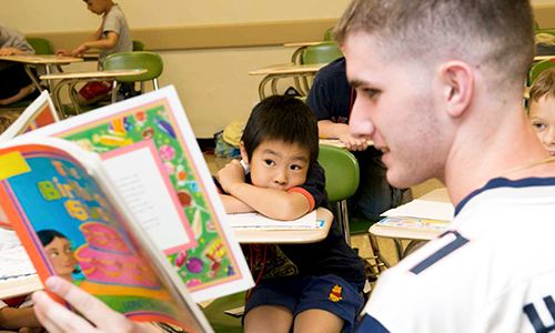 LSOE student reading to children at St. Columbkille school