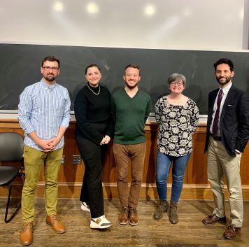 4 students stand with PhD director 