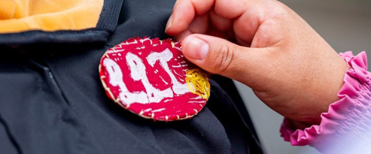 A lapel pin that says "LLI"