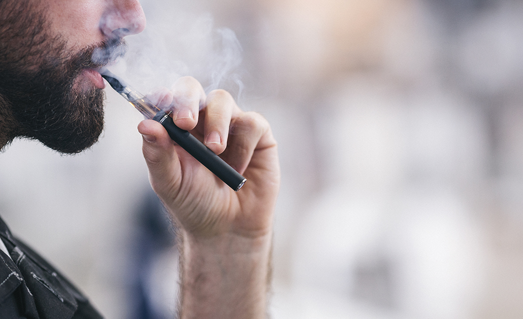 A person uses an e-cigarette